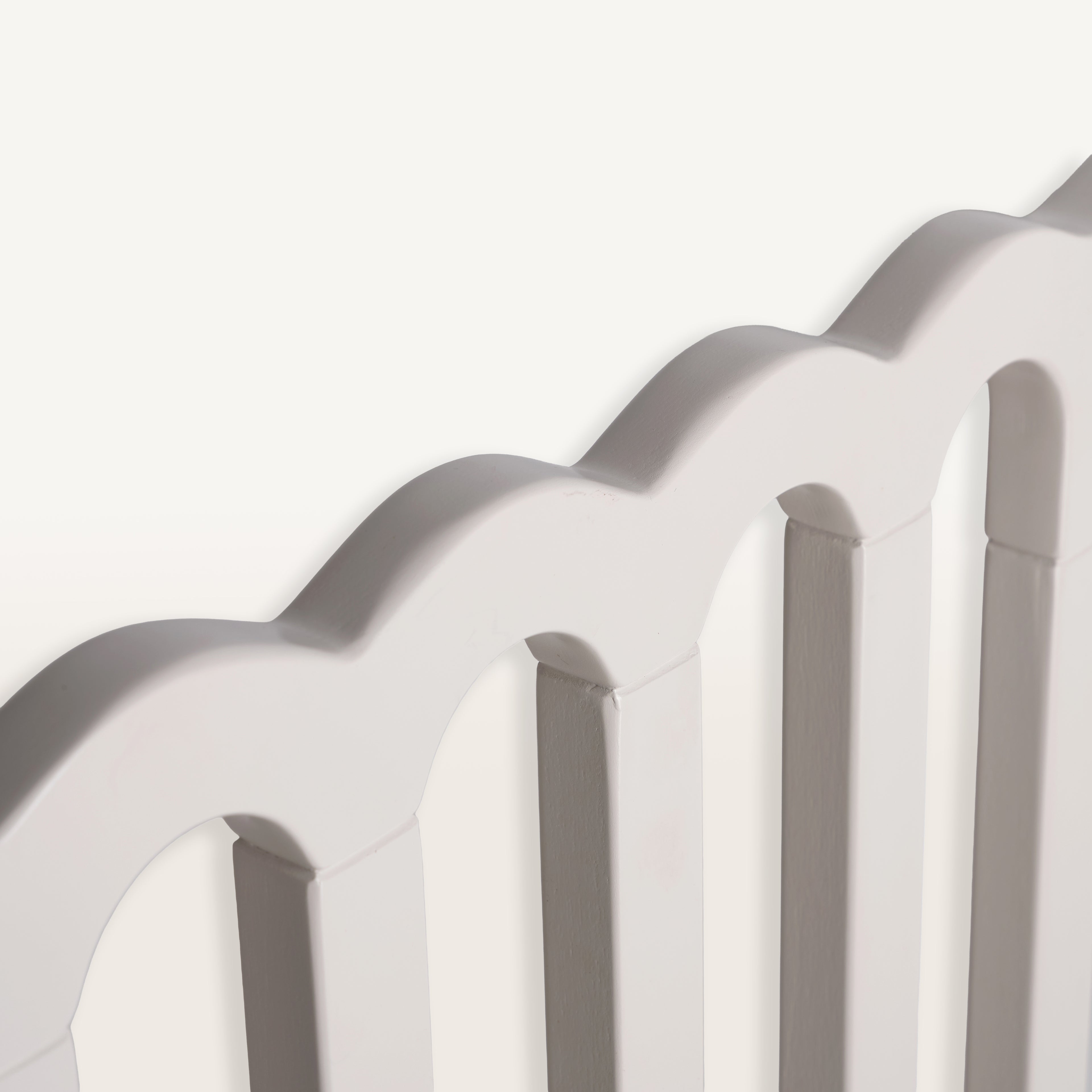 Close-up of a baby gate with a scalloped edge on a white background