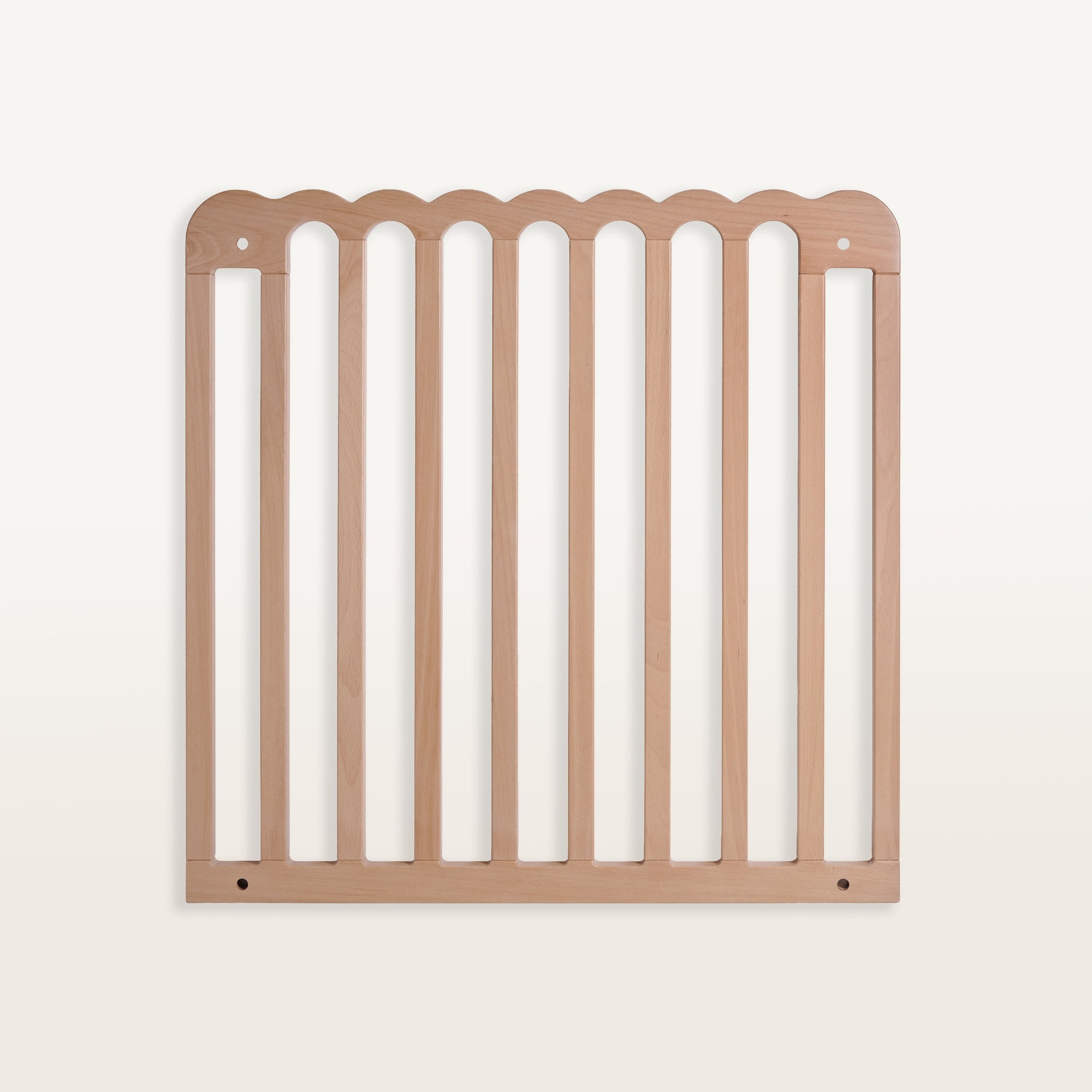 Wooden pet gate with scalloped top edge on a white background